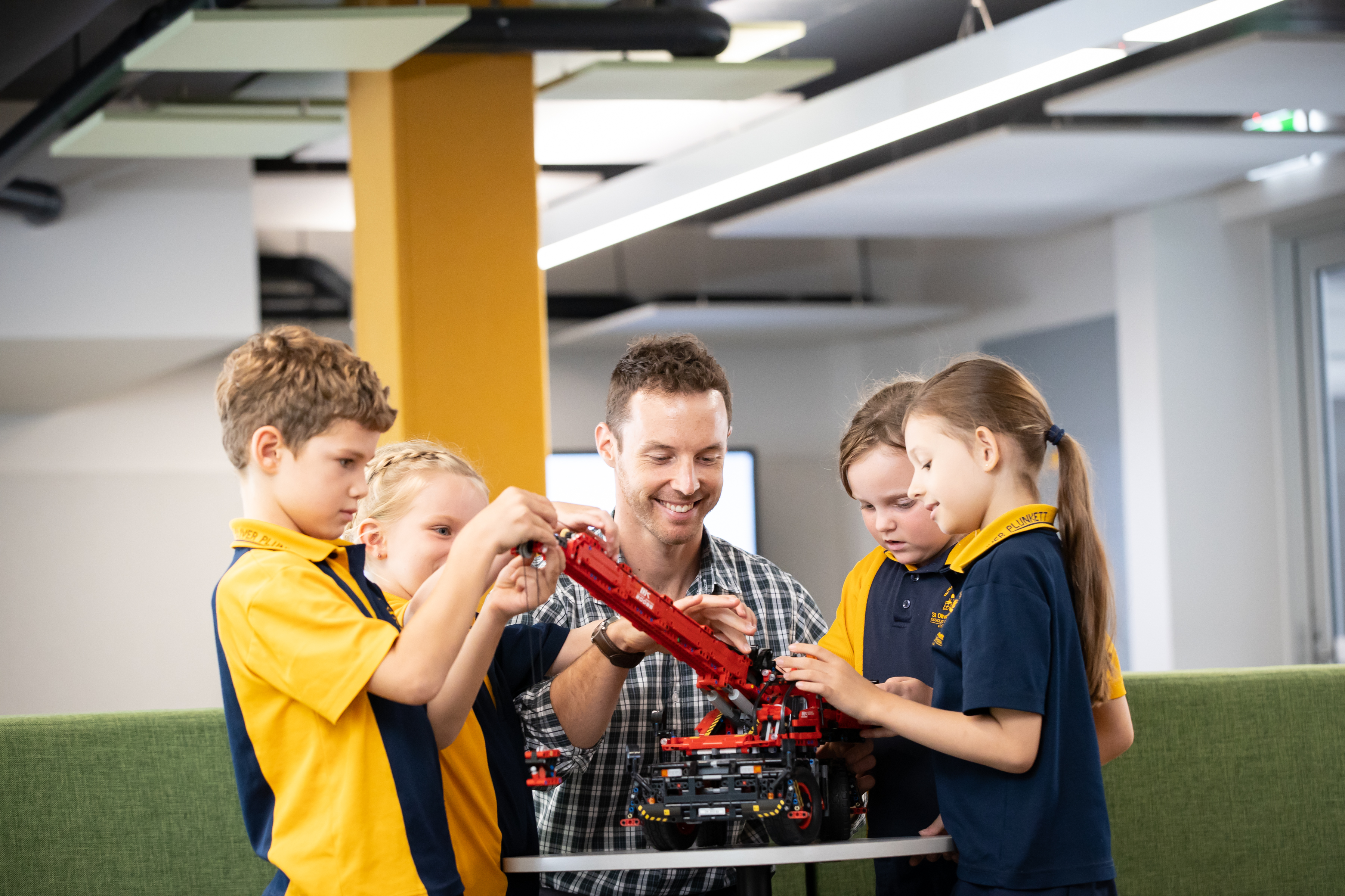 Children are taking part in a guided engineering activity with teacher.